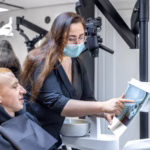Oral surgeon at Ridge Oral Surgery in Summit reviewing a patient's dental X-ray before discussing treatment options.