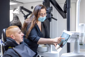Oral surgeon at Ridge Oral Surgery in Summit reviewing a patient's dental X-ray before discussing treatment options.
