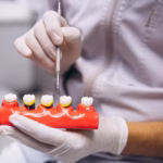 Dentist using a dental implant model to explain zirconia and titanium implant options for replacing missing teeth.