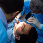 Oral surgeon performing tooth extraction in Ridge Oral Surgery clinic.