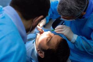 Oral surgeon performing tooth extraction in Ridge Oral Surgery clinic.