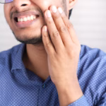 Man experiencing tooth sensitivity and discomfort that may require a dental examination.