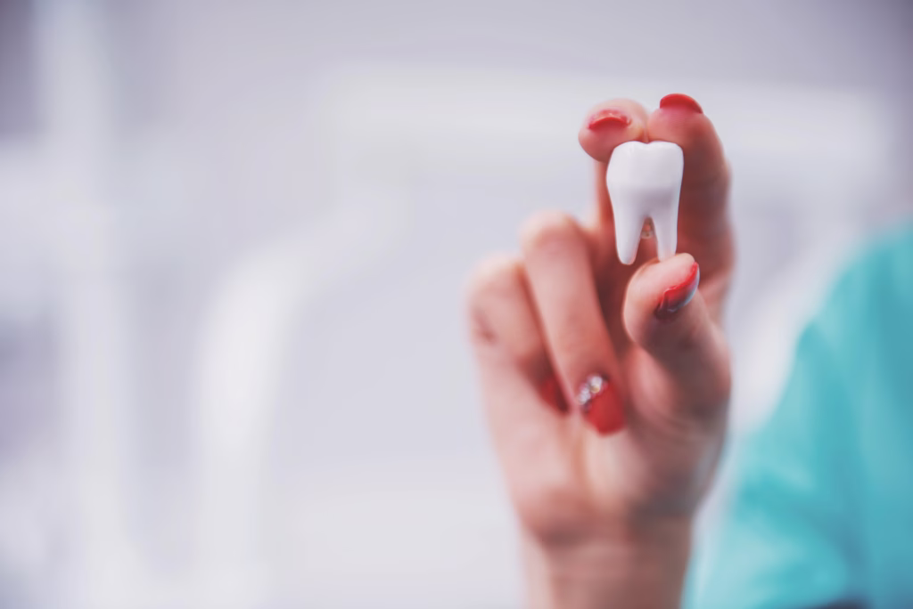 Person holding an extracted tooth after wisdom tooth removal at Ridge Oral Surgery clinic.